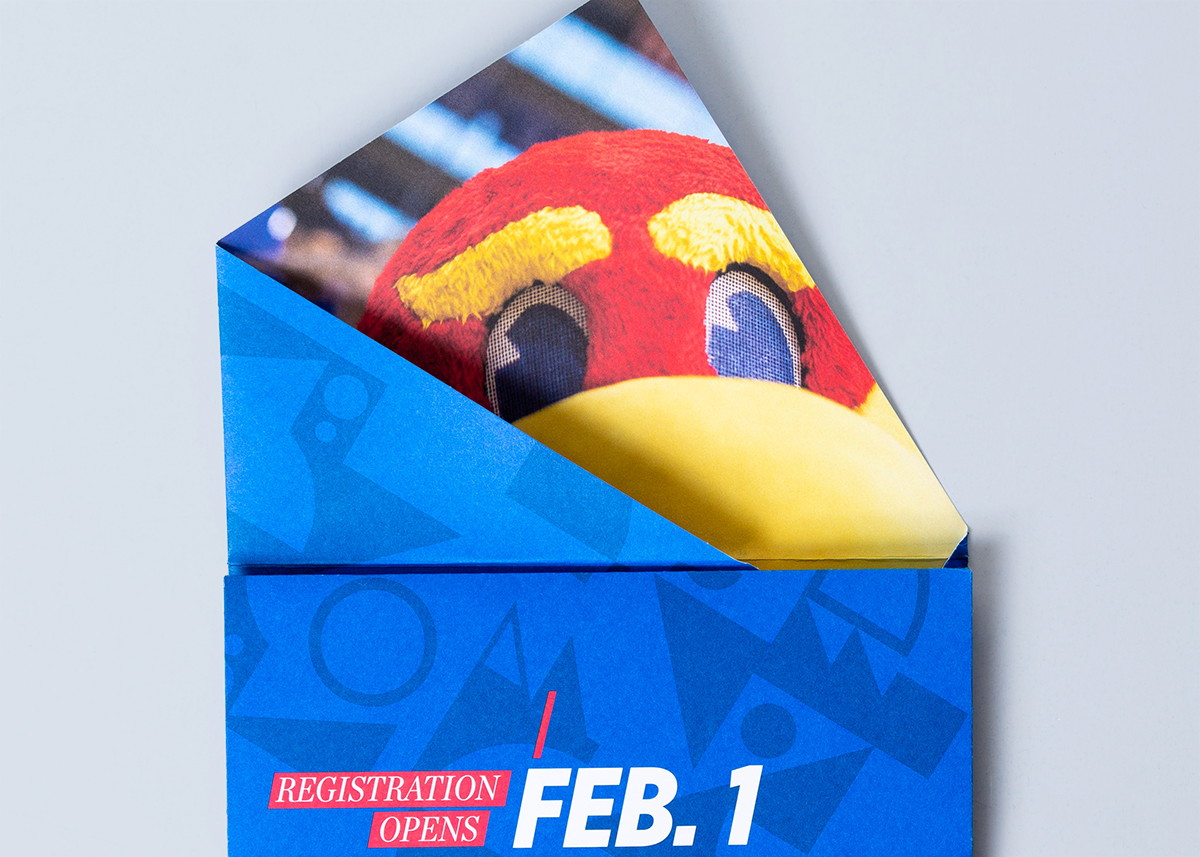 Orientation campaign asymmetrical mailer with Jayhawk peeking out behind a fold